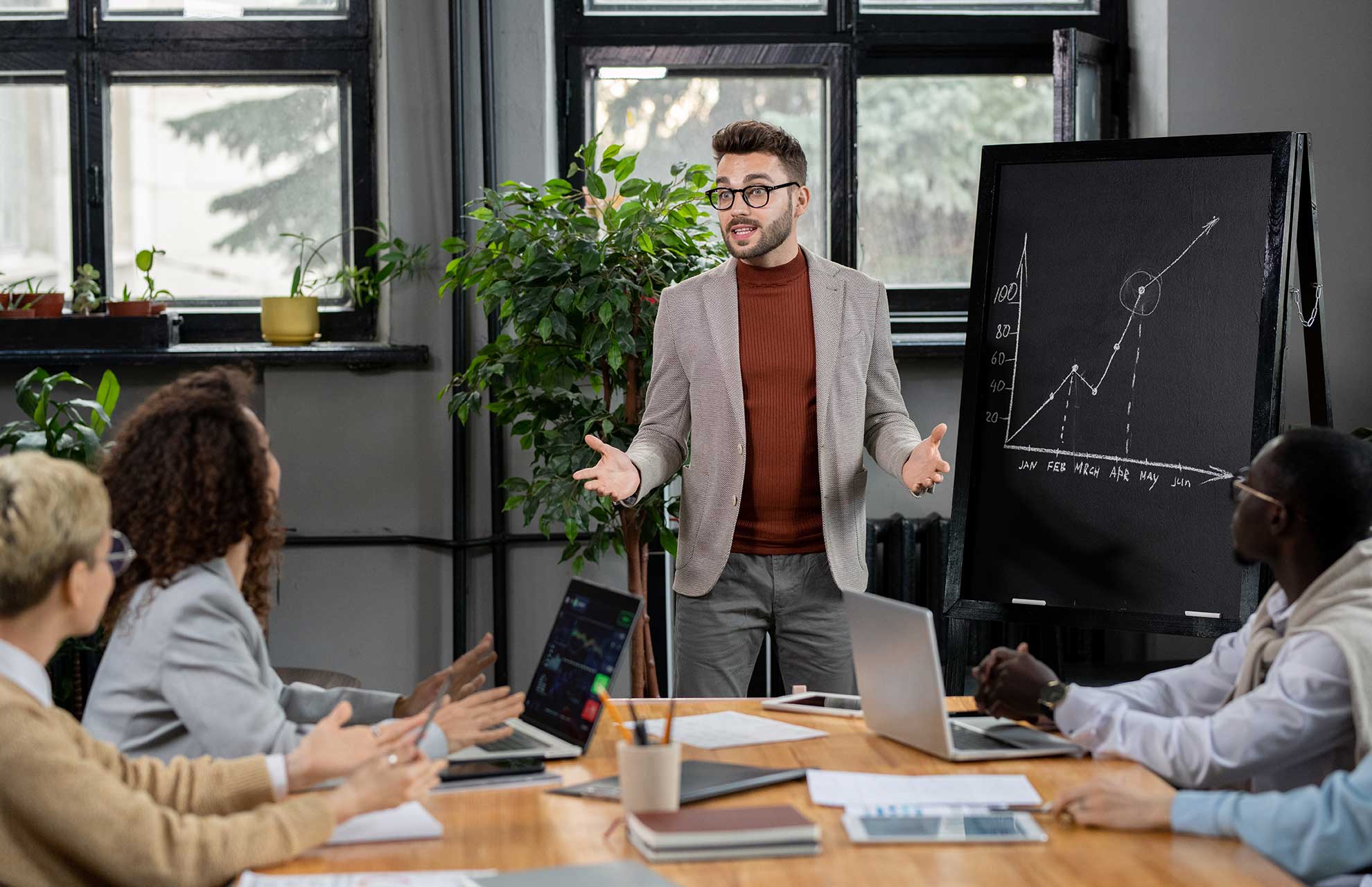 Coach ejecutivo explicando una gráfica de resultados a un joven directivo